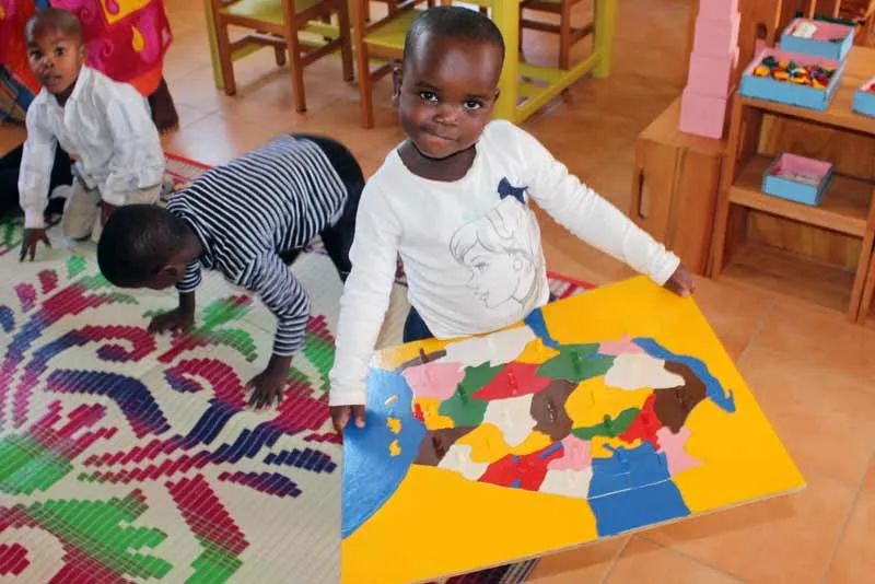 Child holding map of Tanzania - Sponsor a child in Tanzania