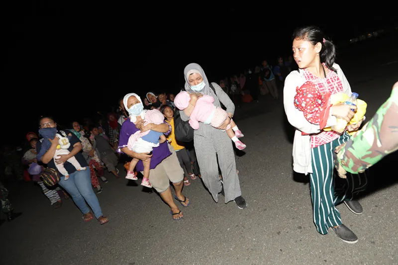 Palu residents, including women and children, at airport during evacuation after tsunami in Indonesia
