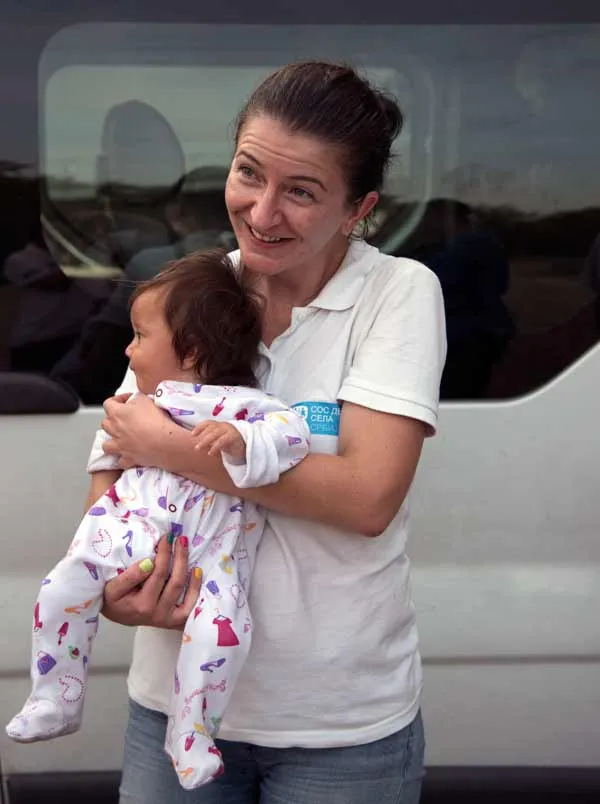Katerina Ilievska holding infant migrant in Serbia