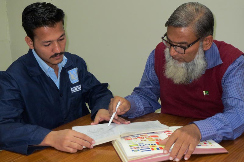 Enseignant et étudiant étudiant ensemble au centre de formation professionnelle de Karachi, au Pakistan