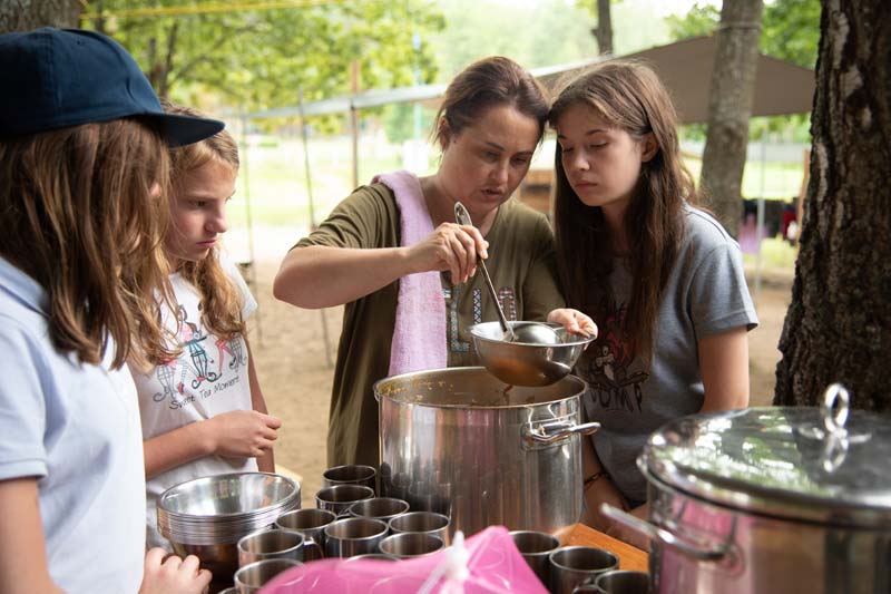 Des adolescents aident à servir de la nourriture dans un camp d'été en Biélorussie