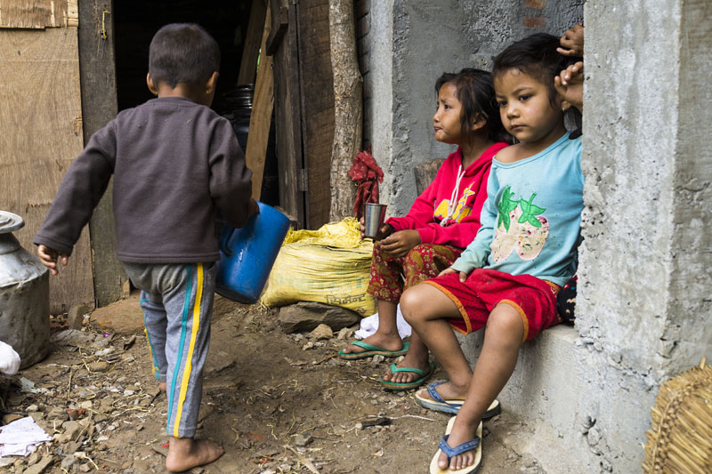 Two girls sit in rubble in Sindhupalchowk, Nepal
