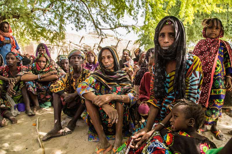 Refugee women sitting on the sand in Niger