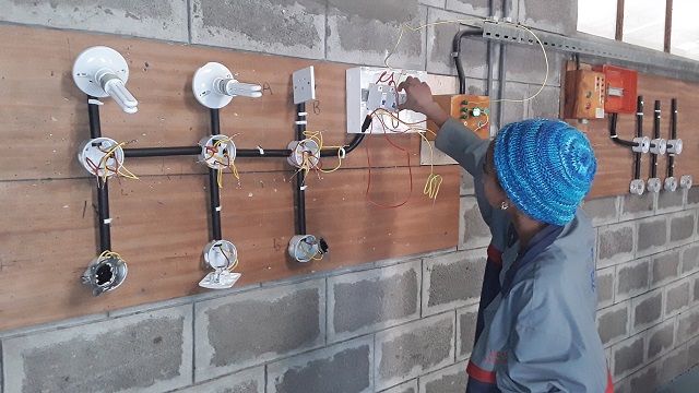 Zala practicing her electrical skills in the classroom.